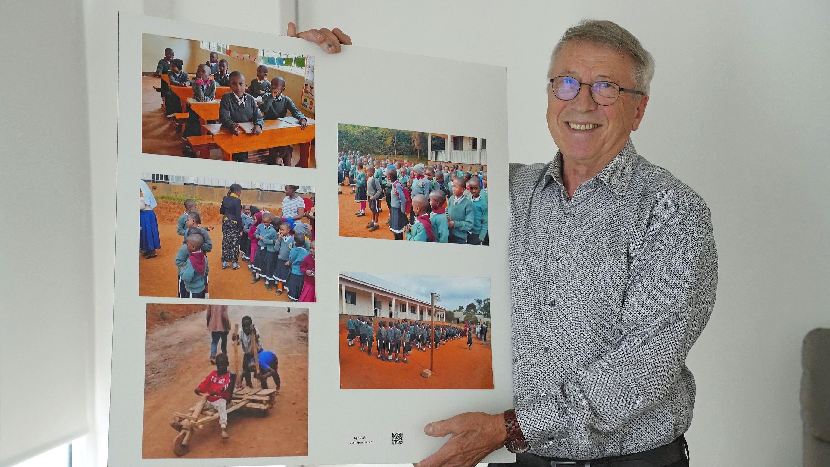 Eduard Kimmlingen zeigt ein Plakat mit Fotos der Projekte in Tansania.