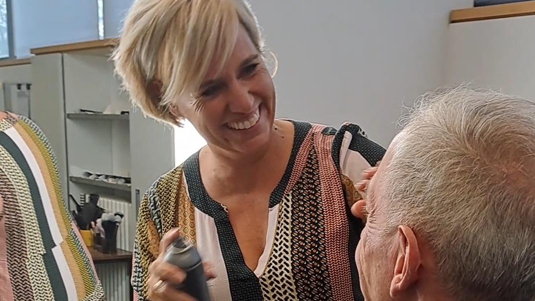 Maskenbildnerin Katja Texter benutzt das Make-up Setting Spray an Pfarrer Benedikt Welter