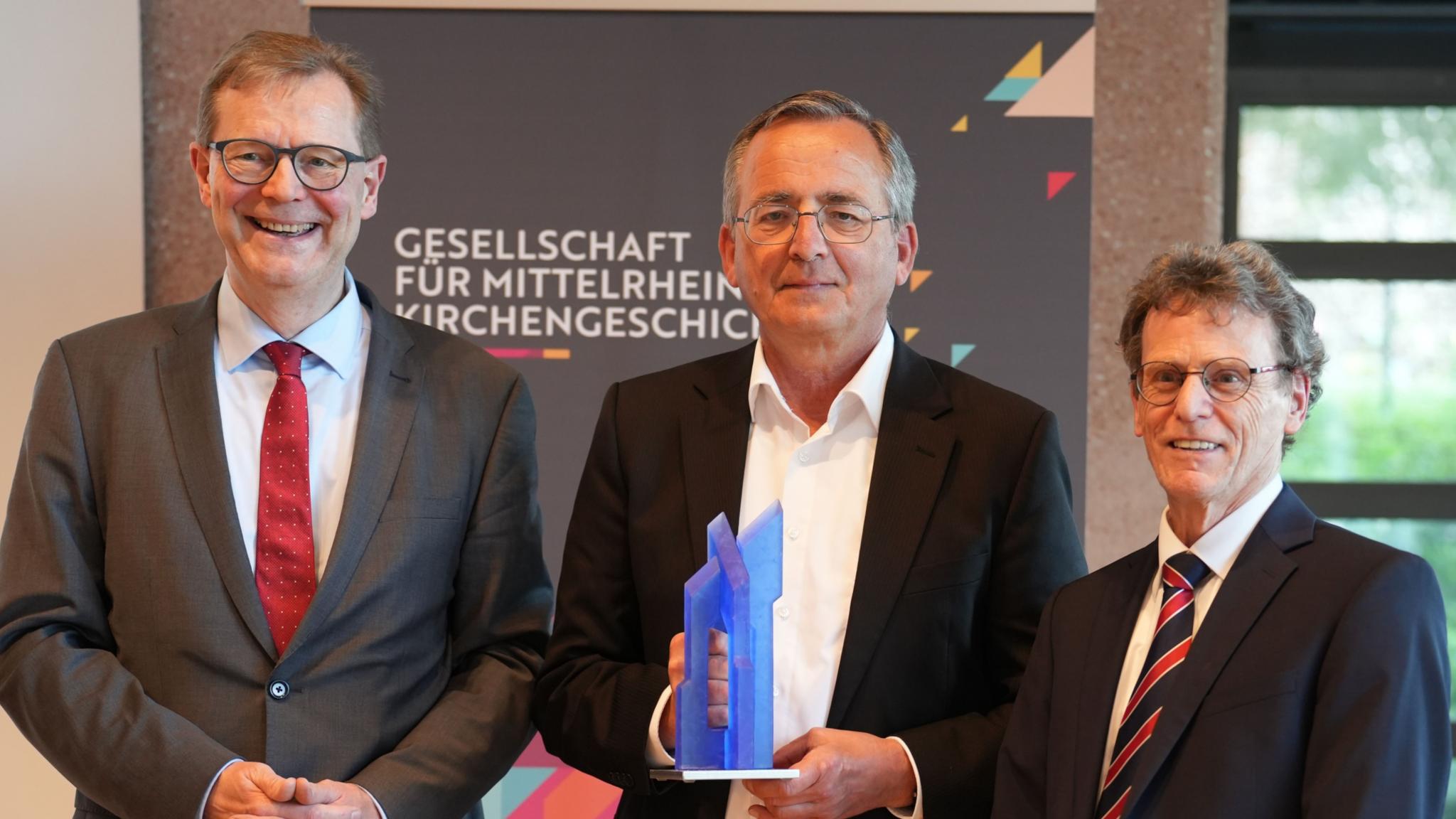 Der neue Vorsitzende Dr. Thomas Brockmann (links) und sein Vorgänger Prof. Dr. Bernhard Schneider (rechts) würdigen Prof. Dr. Wolfgang Schmid mit der Ehrengabe der Gesellschaft.