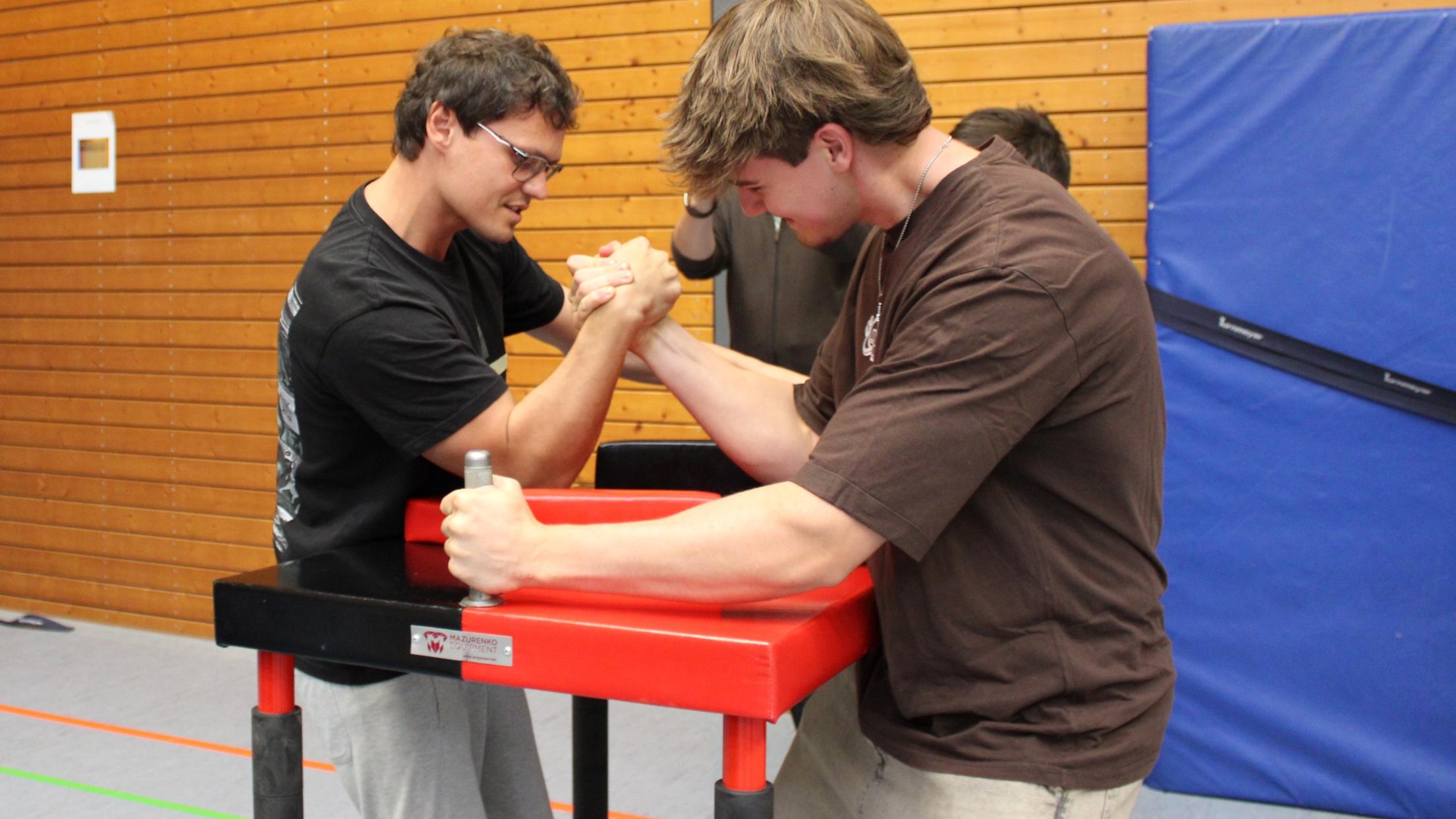 Trainer Evgenij führt Elias ins Armdrücken ein.