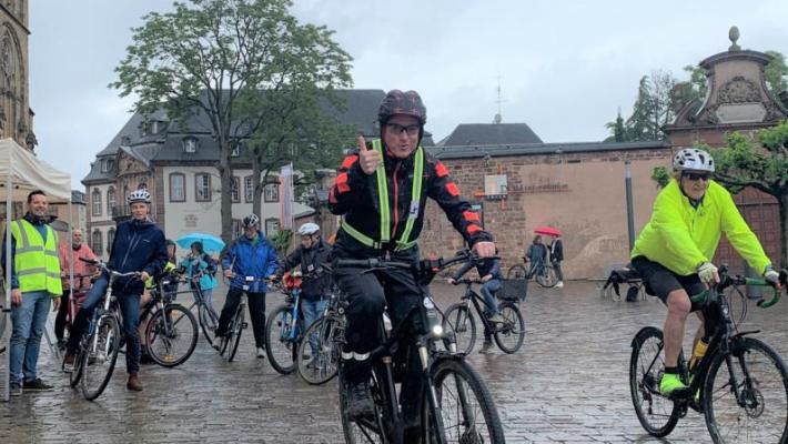 Viele Radfahrer, die im Regen ihre Runden um den Trierer Dom drehen.