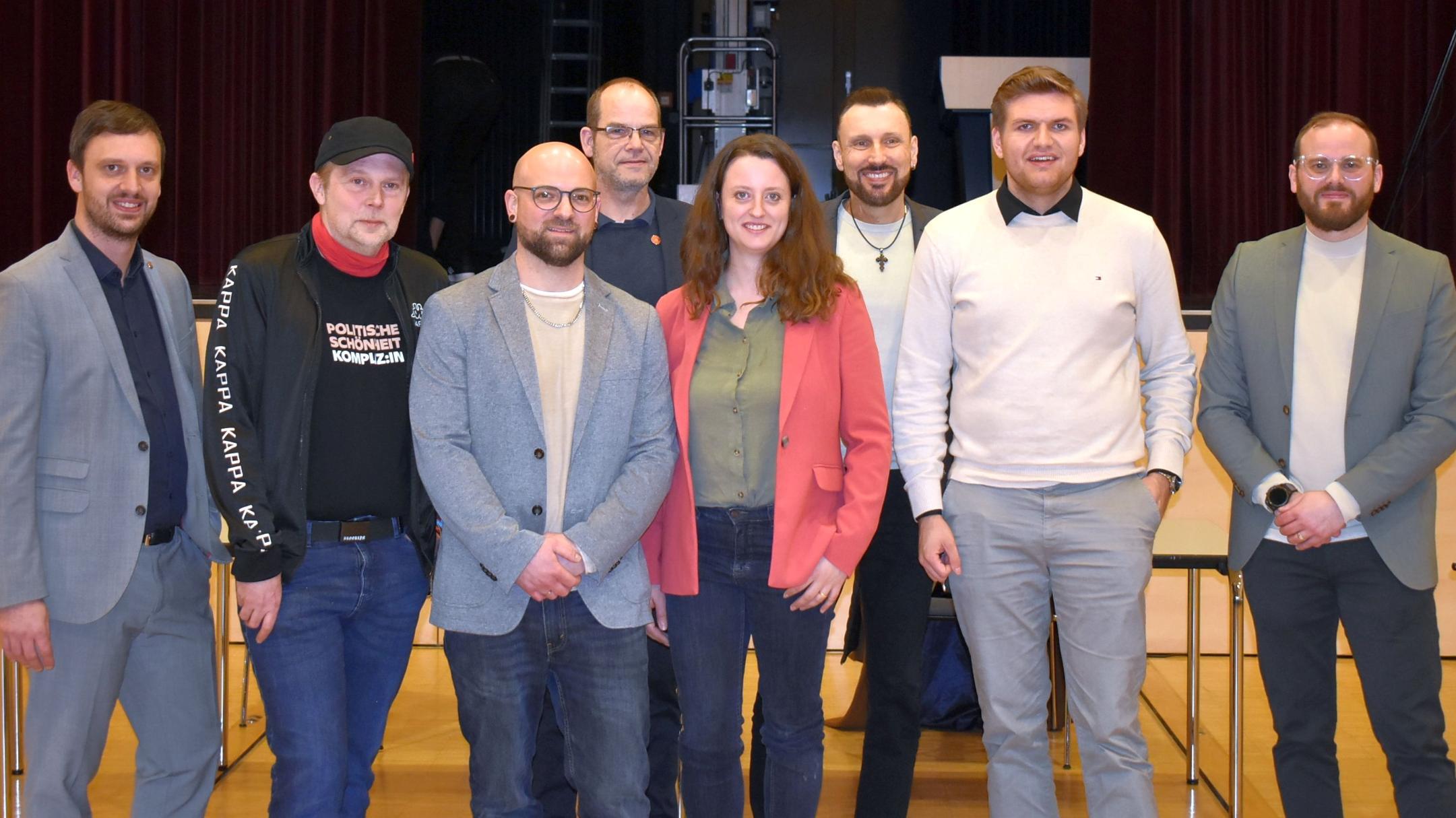 Eine Frau und sieben Männer schauen freundlich in die Kamera.