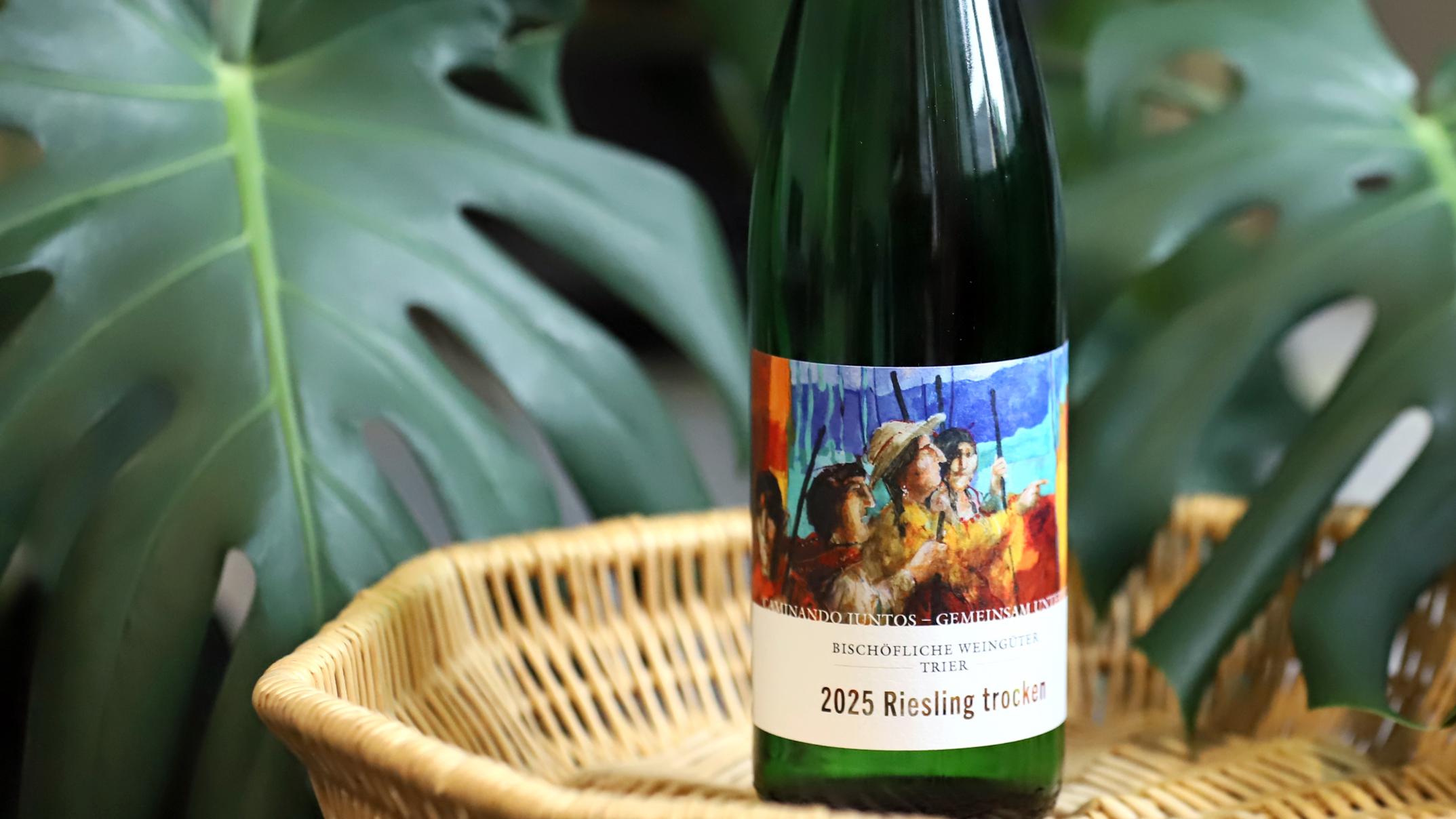 Eine Flasche Partnerschaftswein steht auf einem Tablett. Im Hintergrund eine Pflanze