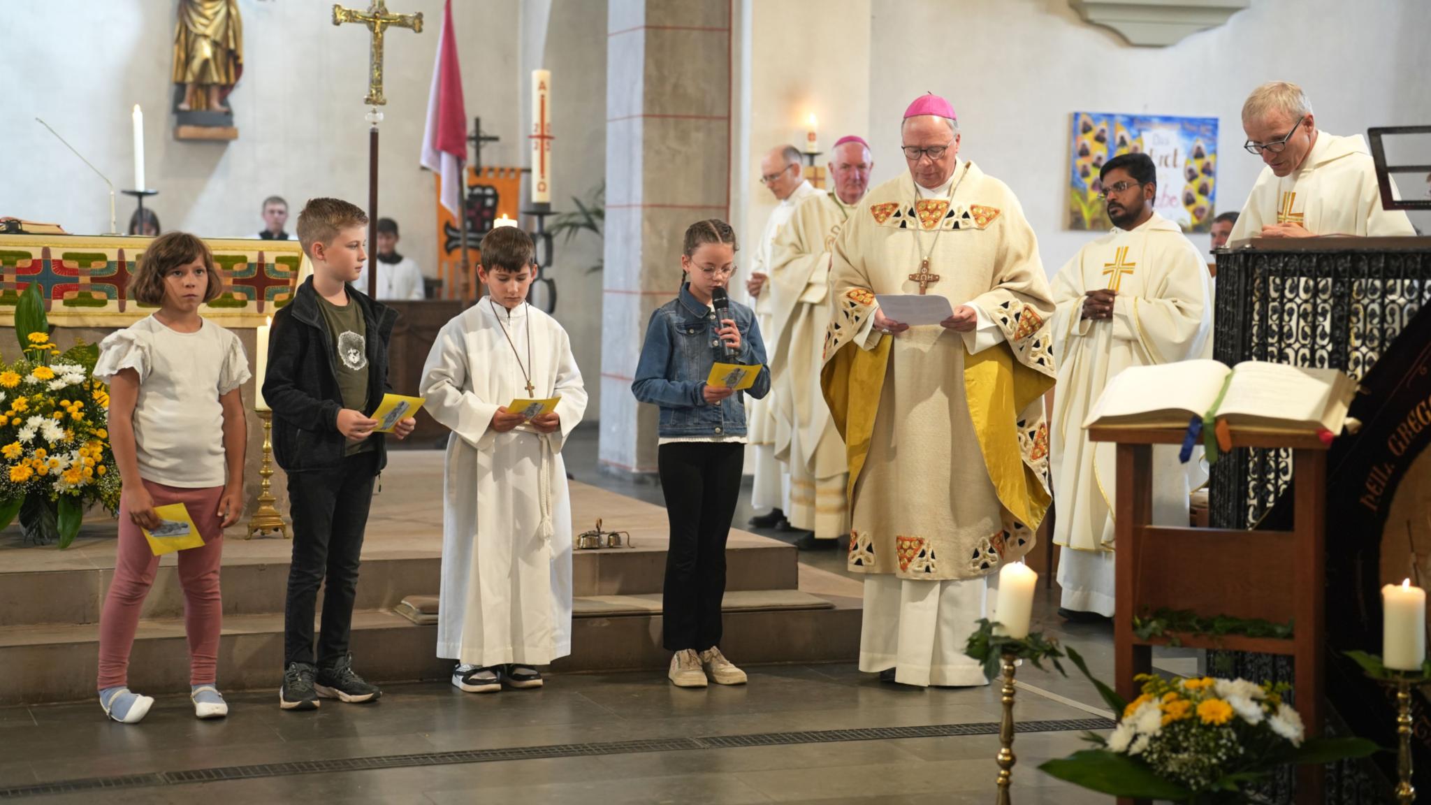 Bischof Stephan Ackermann mit Schülerinnen und Schülern der Gregor-von-Pfalzel-Grundschule, die die Fürbitten sprechen.