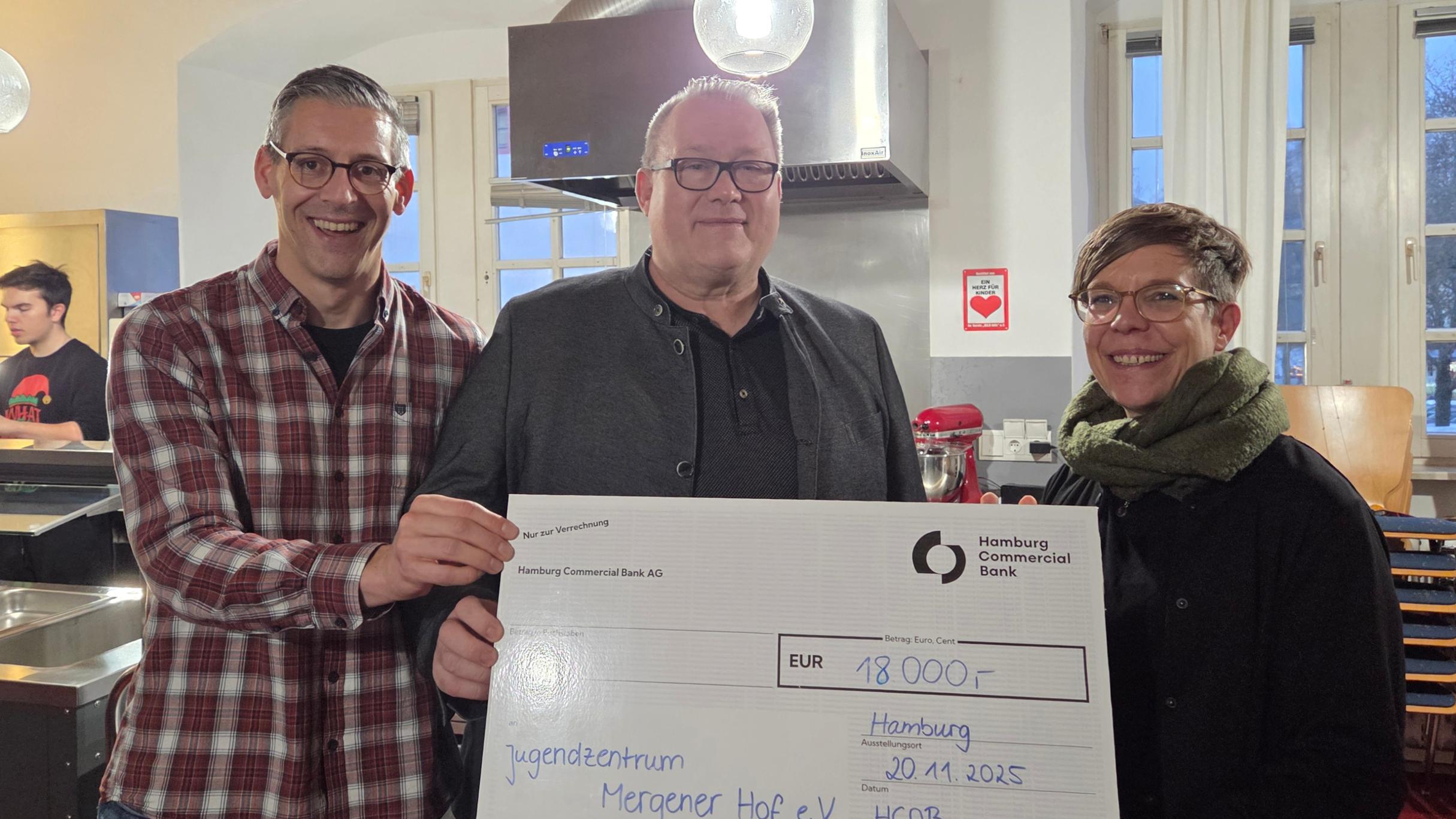 Matthias Ludwig, Leiter des Mergener Hofs, Franz-Josef Glauben und Kerstin Knopp halten einen Scheck in der Höhe von 18.000 Euro für die Miez-Box in die Kamera.