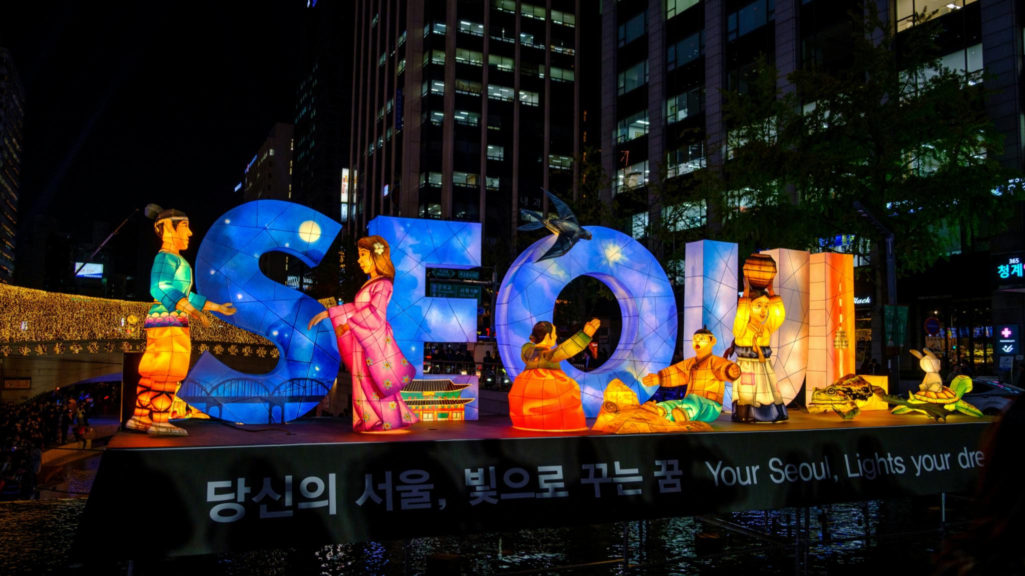 In bunten Farben ist ein Schriftzug Seoul zu sehen in nächtlicher Atmosphäre