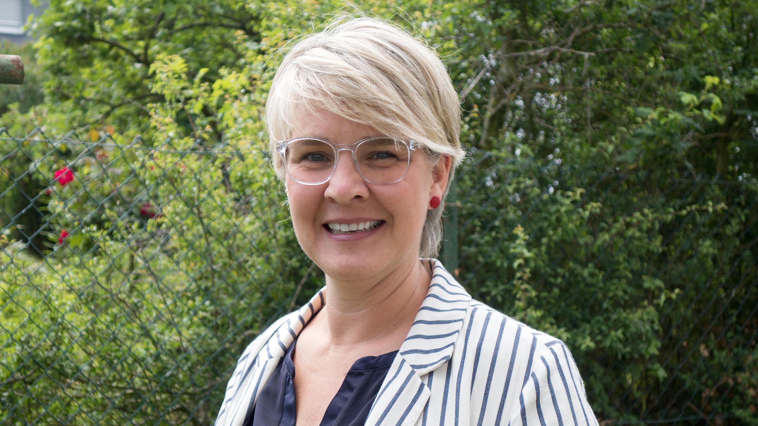 Portraitfoto einer Frau mit Brille und kurzen Haaren